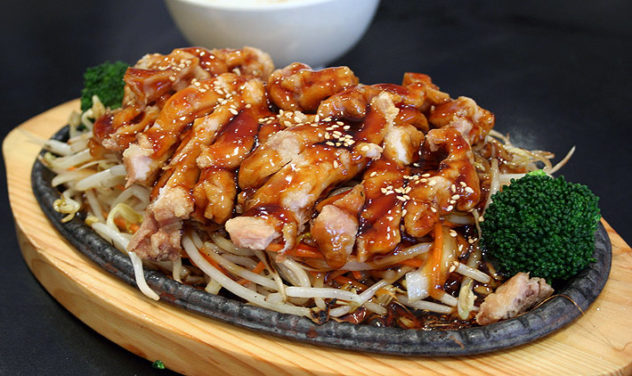 A sizzling plate of chicken teriyaki