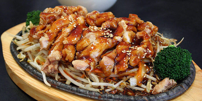 A sizzling plate of chicken teriyaki